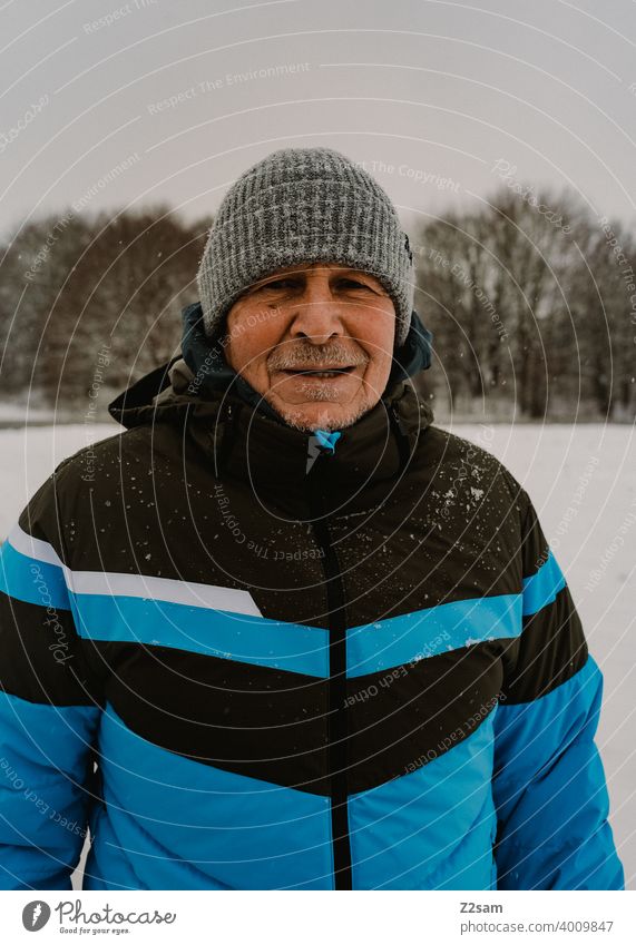 Portrait of a sporty pensioner Pensioners Athletic Man age down jacket Winter chill Cap Laughter kind naturally portrait out warm colors sincerely free time