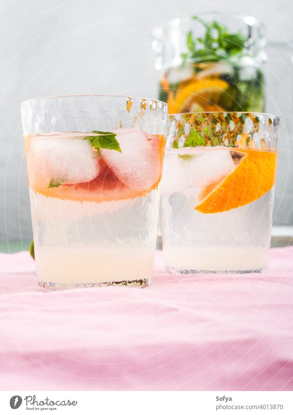 Fresh summer citrus drink in glasses with ice jar cocktail lemonade blood orange lime fruit background infused detox mocktail mint soda water sweet home made