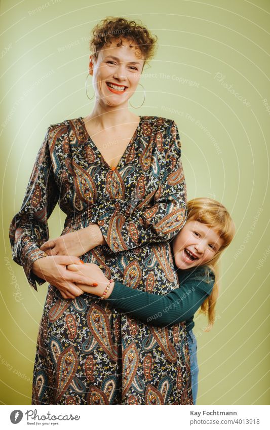 portrait of single mother and her pre-teen daughter against green background adult care caucasian cheerful child childhood cute emotion family female females