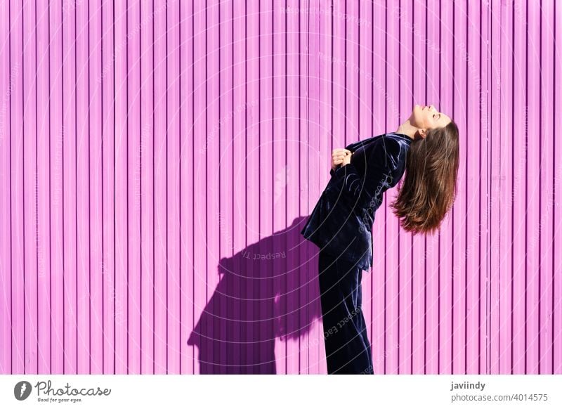 Woman wearing blue suit posing near pink shutter. woman hairstyle fashion model building blind fuchsia purple moving girl person lifestyle female urban