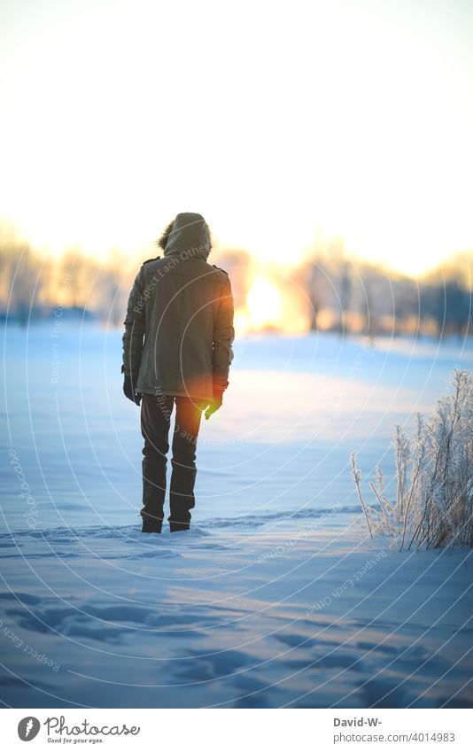 Winter - man standing in the sunlight in a snowy clearing enjoying the last rays of the day's sunshine Winter's day Snow Sunset Man To enjoy winter Sunbeam