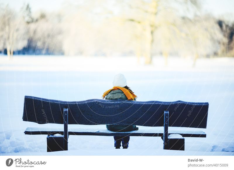 young woman sits on a bench in nature on a cold winter day Winter Bench Landscape Woman Sit Snow To enjoy tranquillity Nature onset of winter Winter mood White