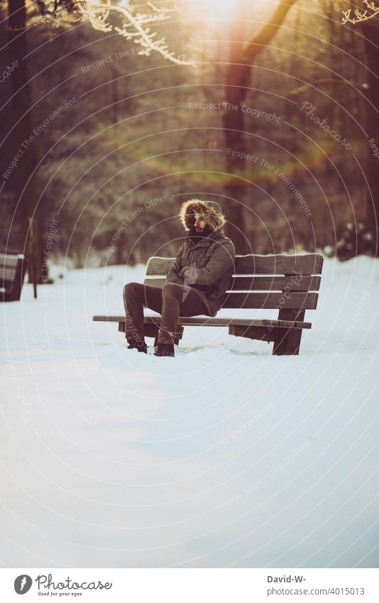 Man sitting freezing on bench in nature in freezing cold weather Freeze Winter Cold Snow White icily Winter's day Winter mood Bench Sit Nature onset of winter