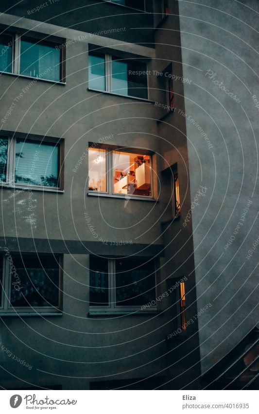 Facade of a residential building in the evening, light is burning in a window. Window Light Apartment Building Fassadr at home Evening Cozy dwell