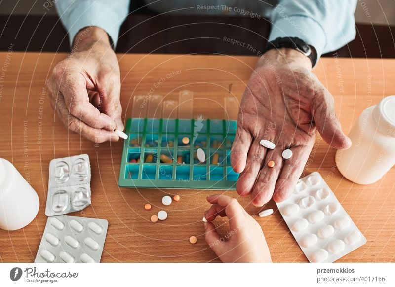 Senior man organizing his medication into pill dispenser. Senior man taking pills from box senior disease patient prescription medical medicine person