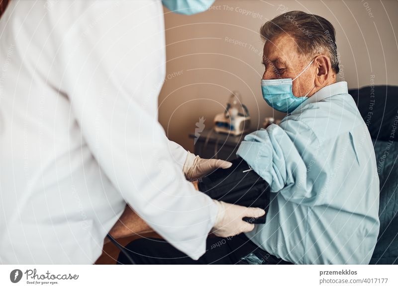 Doctor carying out blood pressure test and heart rate of senior man. Checking health condition elder patient suffering from arterial hypertension nurse check