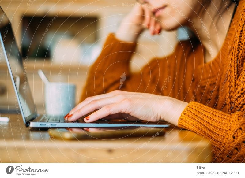 Young woman sitting at the table at home typing something on the notebook Notebook laptop Woman Online Surfing labour home office Home Office Typing Computer