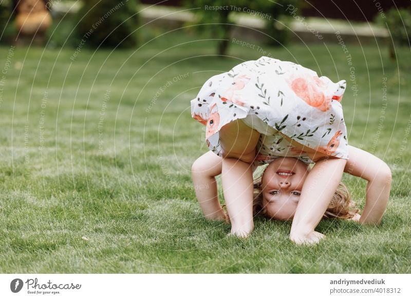 Little happy girl having fun in green summer park. happy chuldhood beautiful child childhood cute nature spring grass young happiness joy little family outdoor