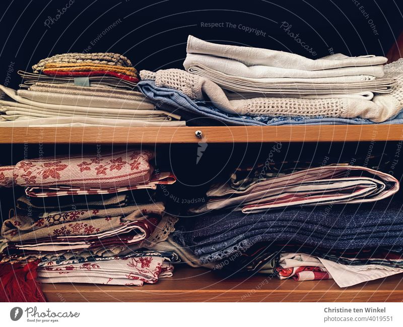 Tablecloths and doilies and old crocheted potholders, stacked more or less neatly in two closet compartments Doily Oven cloth Crocheted Substances