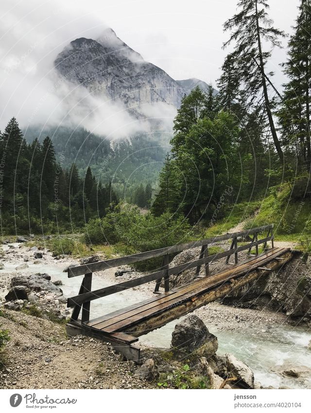 Wooden bridge over a torrent in the Karwendel mountains Bridge Mountain Karwendelgebirge Clouds Brook Mountain stream Tourism Hiking Austria hazy Weather Alps