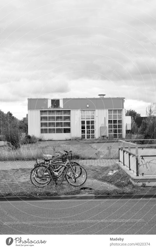 Bicycle stand with bicycles on a green strip in a desolate environment in the industrial area at Hanauer Landstraße in Frankfurt am Main, district Fechenheim