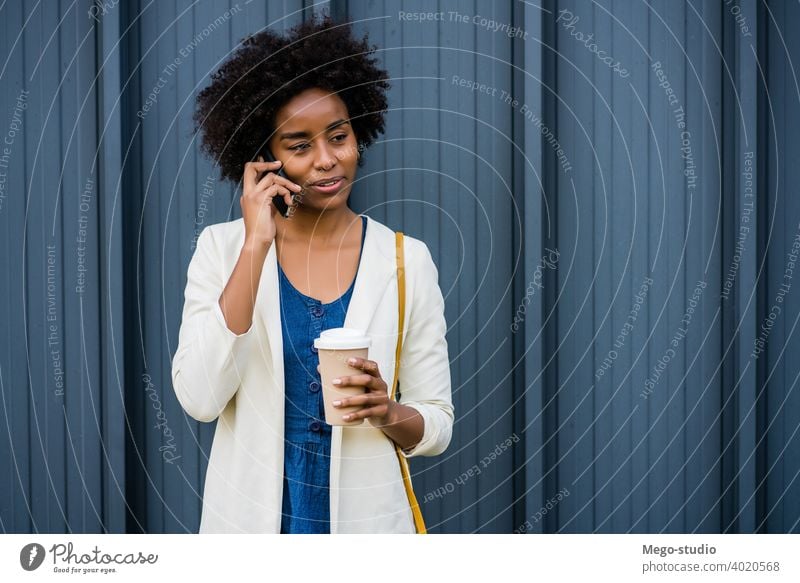 Business woman talking on the phone outdoors. afro business mobile modern style brunette gadget positive concept connection application sms texting