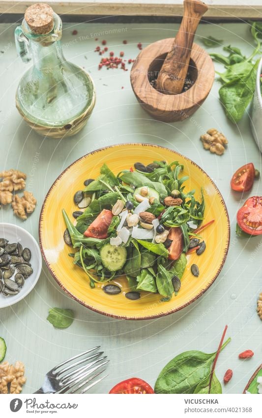 Healthy green vegan salad with nuts on yellow plate. Top view. Vegetarian lunch background concept cuisine delicious detox diet dish fasting food fresh health