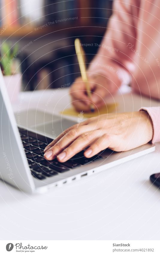 Woman hands writing a note on a white marble desk. woman young working person table female library wooden pen business top background morning girl adult