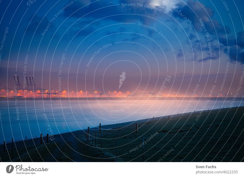 The Jade Weser Port at moonlight in a foggy atmosphere Harbour container port deepwater port Container cargo handling Maritime seafaring Twilight Fog blue hour