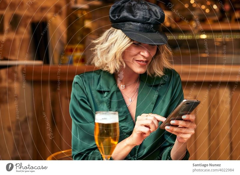 Woman looking at her smartphone at a bar. couple adult woman happy female restaurant lifestyle caucasian beautiful happiness drink smile fun love joy