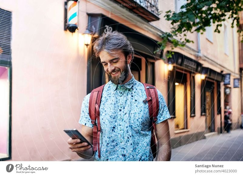 Man looking at his phone on the streets. adult happy lifestyle caucasian happiness smile fun love joy leisure cheerful laughing date smiling enjoyment 30s