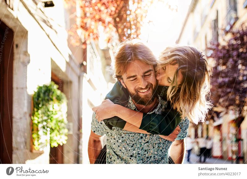 Woman piggyback on man on street. couple adult woman people happy female lifestyle two caucasian beautiful happiness together drink smile fun love joy boyfriend