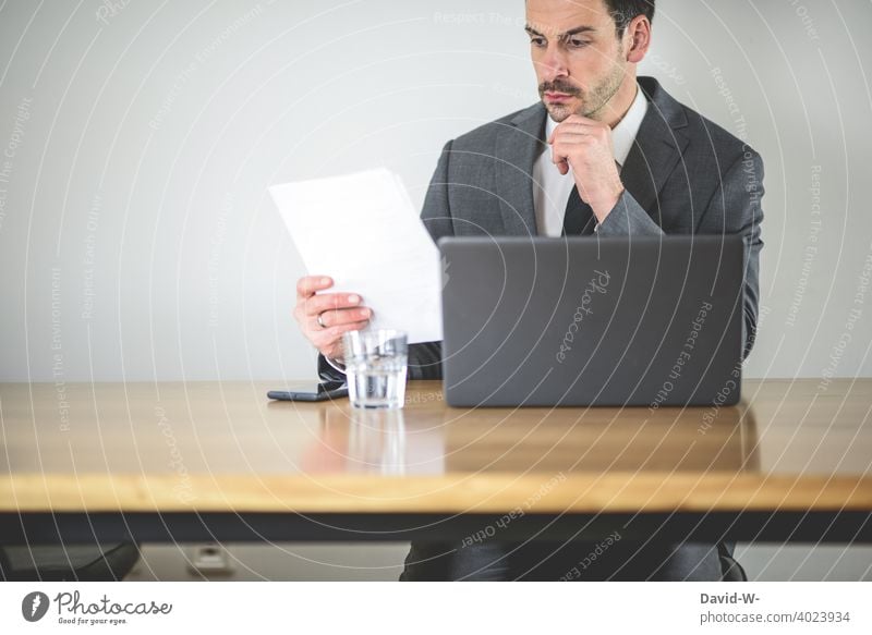 skeptical man at laptop at work labour Man check home office Skeptical keep tabs on sb./sth. Workplace Notebook doubt Insecure critical suspicious Computer