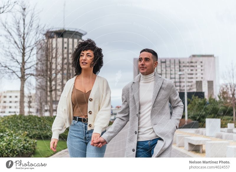 Shallow focus of a young couple holding hands and walking in a park under a cloudy sk shallow sky love woman people together male relationship happy two