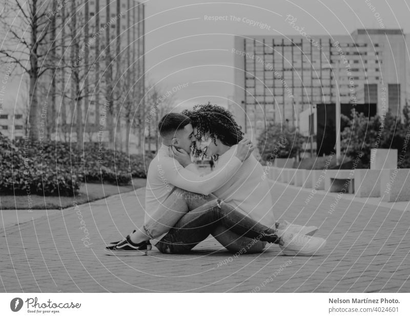 Black and white shallow focus of a romantic young couple kissing on a pavement under a cloudy sky outdoors woman romance together female happiness people adult