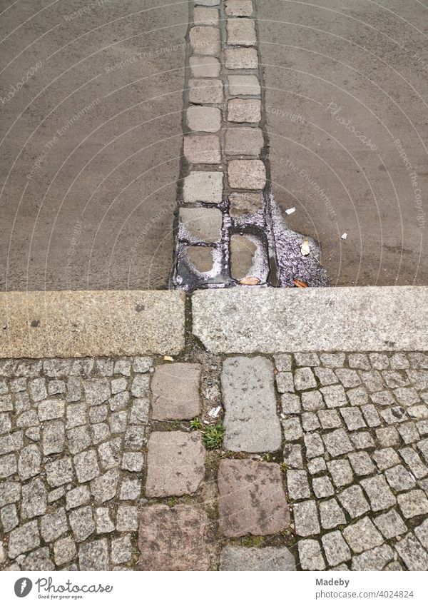 Paving stones embedded in the asphalt mark the course of the Berlin Wall along the sector border at the former Checkpoint Charlie in the capital Berlin.