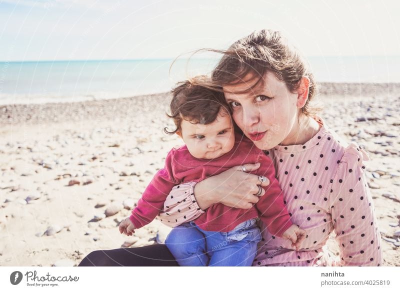 Happy family moment of a young mom enjoying a day on the beach with her baby love holidays happiness lifestyle sun sunny summer trendy fashion mother parenthood