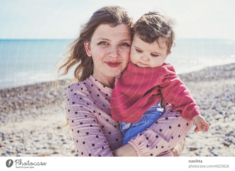 Happy family moment of a young mom enjoying a day on the beach with her baby love holidays happiness lifestyle sun sunny summer trendy fashion mother parenthood