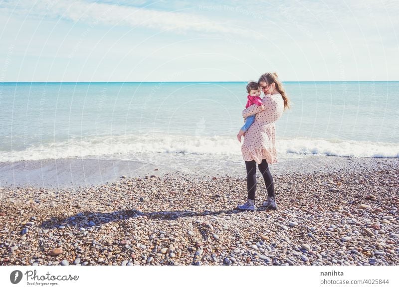 Happy family moment of a young mom enjoying a day on the beach with her baby love holidays happiness lifestyle sun sunny summer trendy fashion mother parenthood