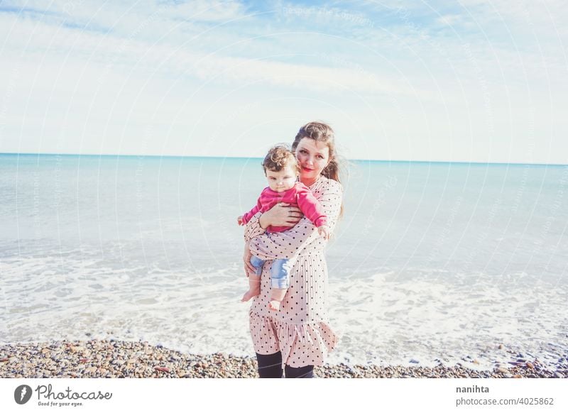 Happy family moment of a young mom enjoying a day on the beach with her baby love holidays happiness lifestyle sun sunny summer trendy fashion mother parenthood