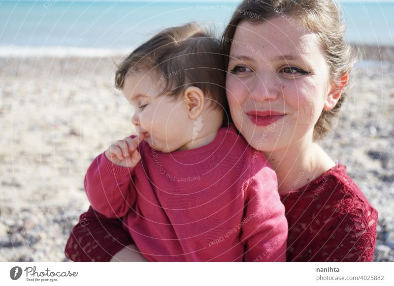 Happy family moment of a young mom enjoying a day on the beach with her baby love holidays happiness lifestyle sun sunny summer trendy fashion mother parenthood