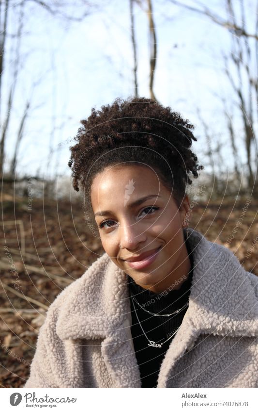 Young woman in fur jacket standing in nature by a lake Woman Athletic Dark-haired Long-haired pretty Strong Graceful naturally Curly Slim Nature from Jewellery