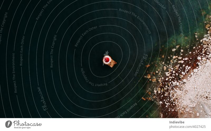 Top view drone shot of a red lighthouse near the shore in United Kingdom, Eastbourne. Summer image with ocean for travel related topics. top view sea blue