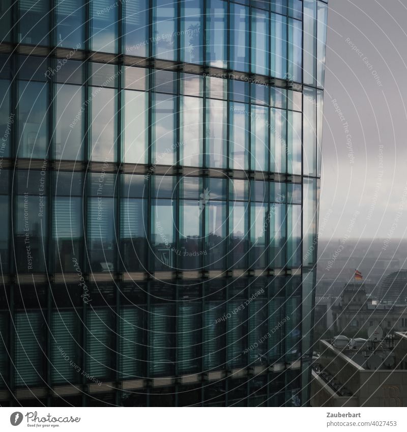 High-rise with glass facade at Potsdamer Platz in Berlin in front of Reichstag Glass Glas facade reflection Clouds somber cityscape Architecture Modern Building