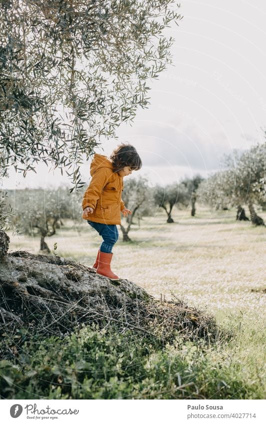 Child playing outdoor Climbing Playing Nature Orange Red Authentic Girl Tree Colour photo Leisure and hobbies Exterior shot Joy Playground Human being Infancy