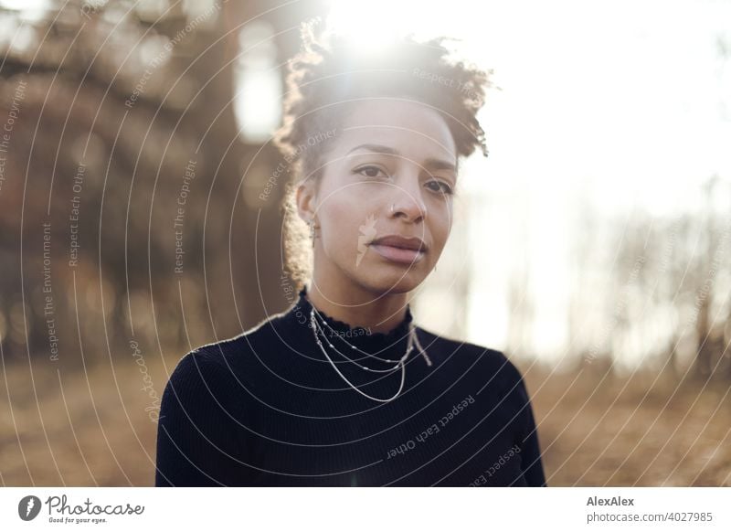 Young woman standing in nature by a lake Woman Athletic Dark-haired Long-haired pretty Strong Graceful naturally Curly Slim Back-light Nature from Jewellery