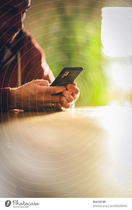 Man on mobile phone Cellphone Typing Table Sit concentrated smartphone Internet Fingers hands Technology Sunlight