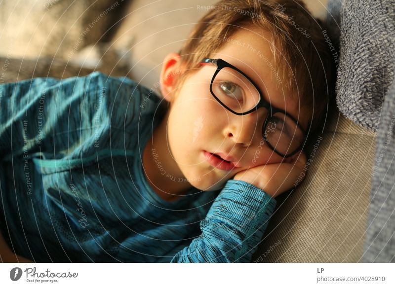 beautiful child wearing glasses looking very serious away from the camera puzzled Perplexed sceptical scepticism doubts Doubt hestitate uncertainty confusion