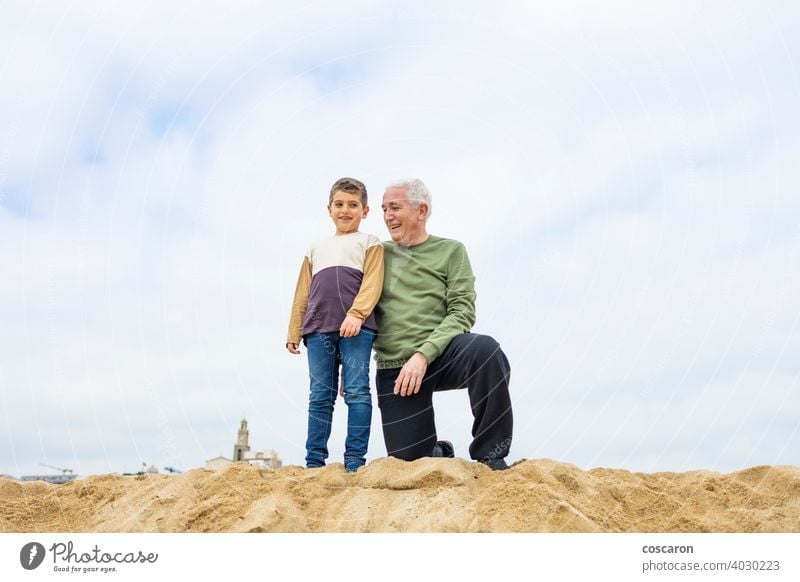 Little boy and his grandfather spending time on the beach baby beautiful cheerful child coast cute enjoying family fun generations girl grandchild grandparent