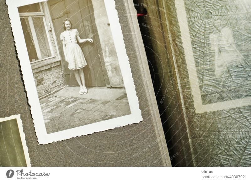 Looking into an old photo album at a black and white photo from the 1940s with deckle edge, showing a young woman / memories / analogue photography Photo album