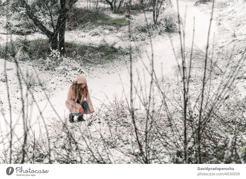 beautiful woman touching snow in forest winter enjoy smile warm clothes content weekend woods wintertime snowfall cheerful happy optimist positive hat coat