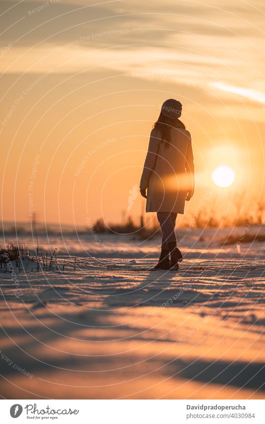 Woman enjoying sunset in snowy field winter countryside nature alone season fresh cold sundown recreation lifestyle weather wintertime harmony calm scenic