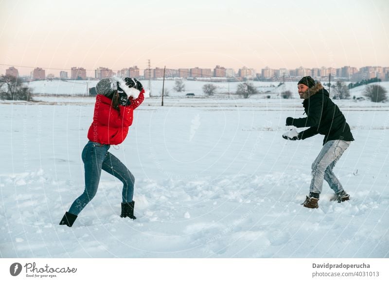 Cheerful couple playing snowballs in winter field having fun cheerful enjoy together countryside love romantic relationship affection fondness girlfriend