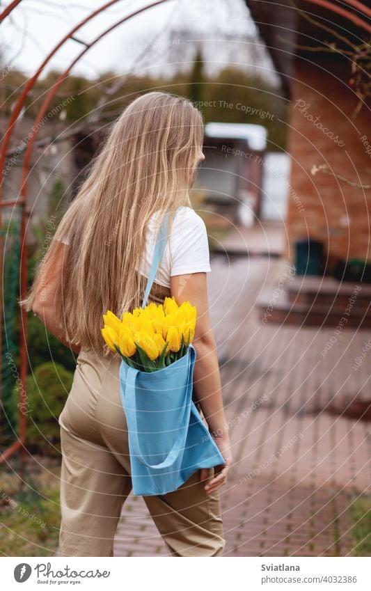 Portrait of a happy female florist with a bouquet of yellow tulips. Women's Day, Valentine's Day, Mother's Day bunch portrait woman romantic valentines day