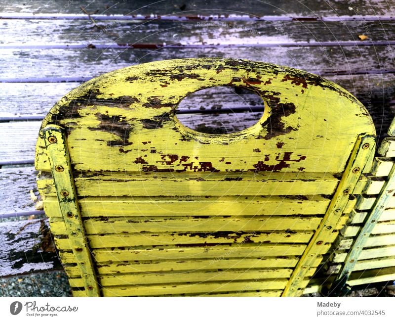 Yellowed folding wooden chair in front of a café in Bielefeld in the Teutoburg Forest in East Westphalia-Lippe Chair Folding chair Wooden chair morbid Old