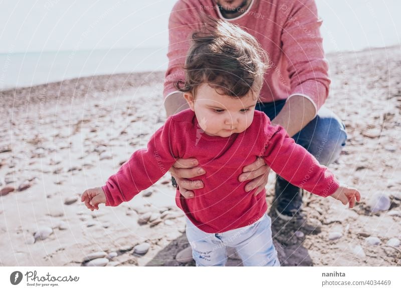 Young dad have a great day at the beach with his dauther family baby holidays happiness happy family time real people kid child little girl sunny father parent