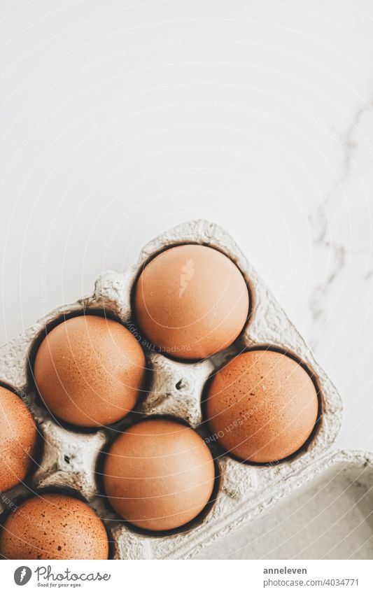 organic eggs in egg box on white marble kitchen table authentic breakfast brown cardboard carton chicken cinematic closeup container copyspace easter eat