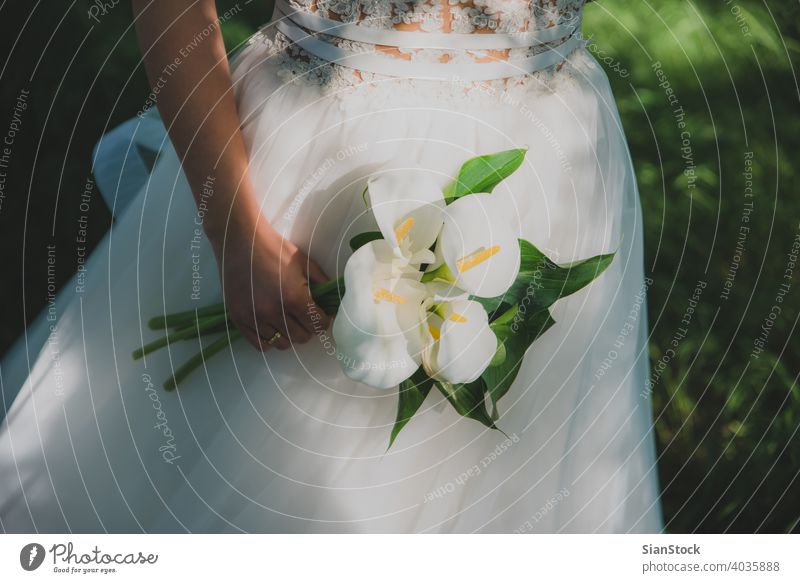 Young beautiful bride holding a bouquet. wedding dress white flowers beauty woman girl young bridal nature trees celebration love elegance background happy