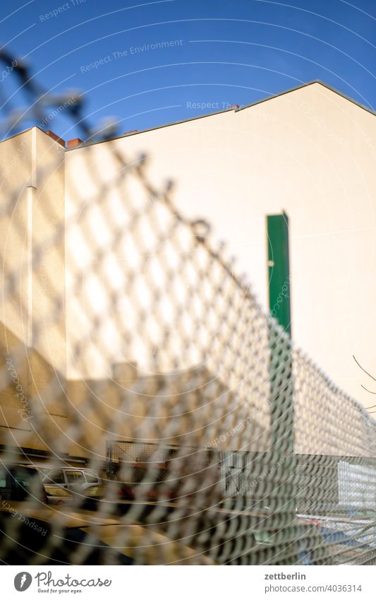 Chain link fence with backyard facade Old building on the outside Fire wall Facade House (Residential Structure) Sky Sky blue rear building Backyard Courtyard