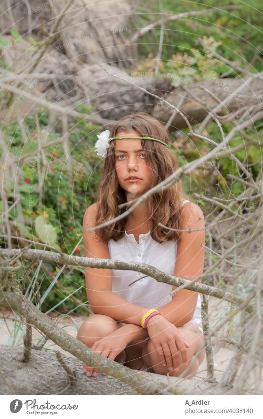 Young girl with flower in hair sits on beach vacation Beach Girl Woman YYG pretty Summer Vacation & Travel Sand Joy Relaxation shrubby Bushes branches trees